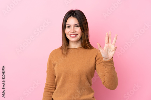 Young woman over isolated pink background happy and counting four with fingers