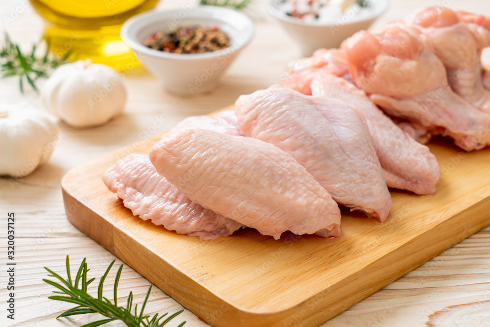 fresh raw chicken wings on wooden board