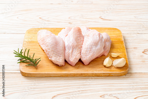 fresh raw middle chicken wings on wooden board photo