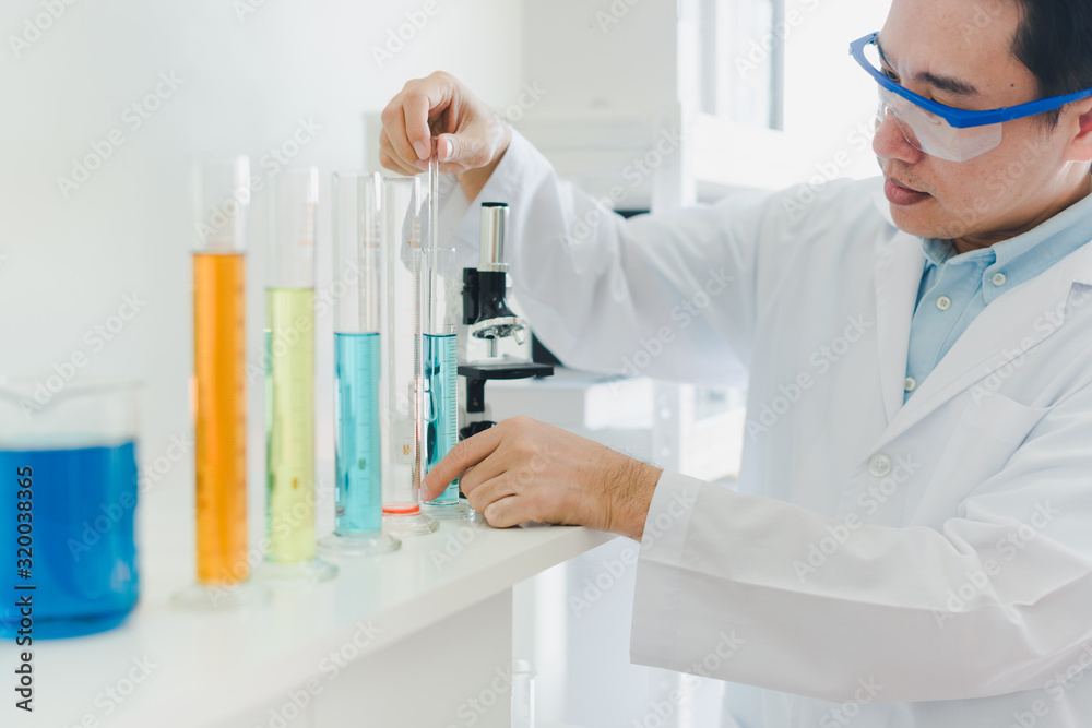 Asian scientists are preparing chemicals for testing and analysis in the laboratory. Scientists clear glasses and white shirts. Science and Chemistry Concept Asian scientists are preparing chemicals for testing and analysis in the laboratory. Scientists clear glasses and white shirts. Science and Chemistry Concept