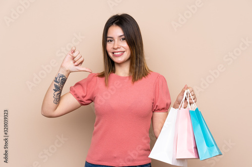 Young woman with shopping bag over isolated background proud and self-satisfied