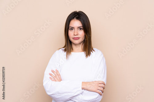 Young woman over isolated background keeping arms crossed
