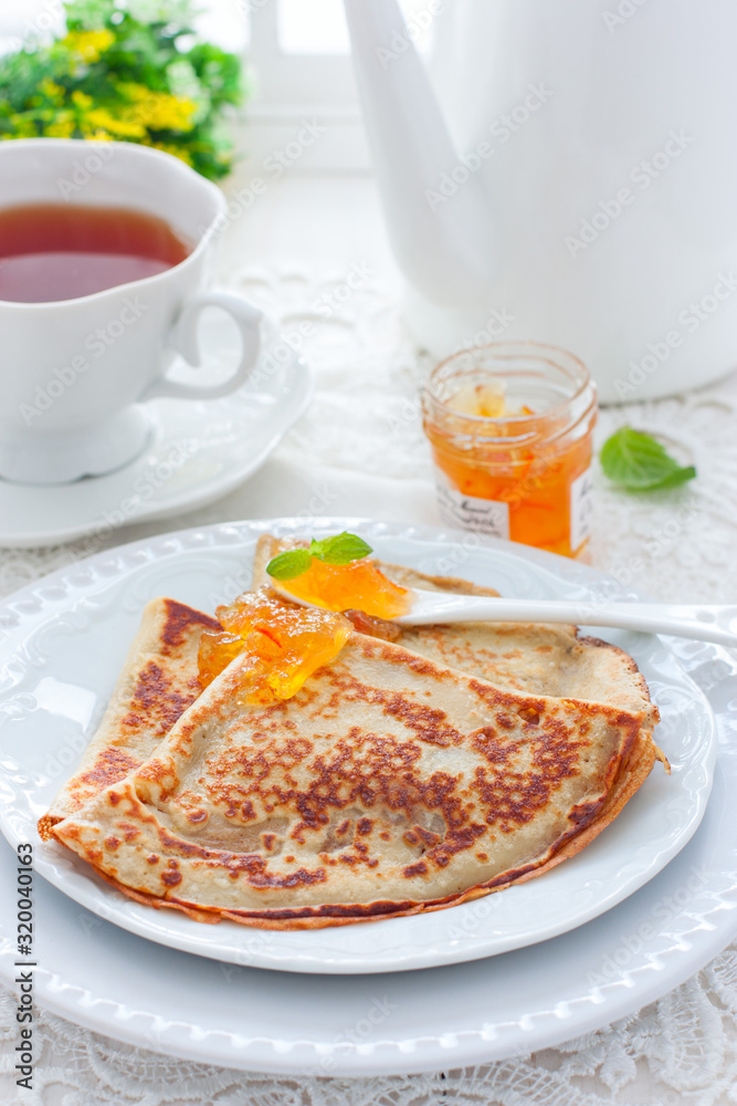 Breakfast with pancakes and orange jam, selective focus Breakfast with pancakes and orange jam, selective focus