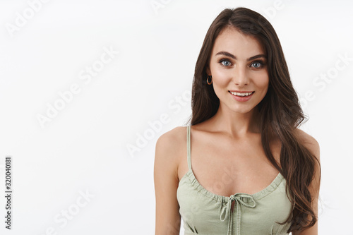 Happiness, women and beauty concept. Waist-up portrait alluring dreamy brunette female in dress, smiling white teeth, looking delighted and upbeat, express positivity and perfection © Cookie Studio