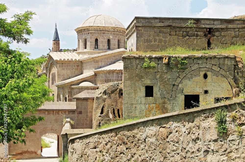 The ruins of historic buildings and the ancient mosque in the background in the city of Guzelyurt in Turkey