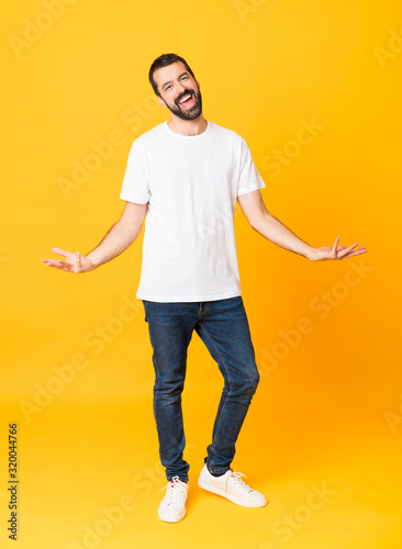 Full-length shot of man with beard over isolated yellow background smiling