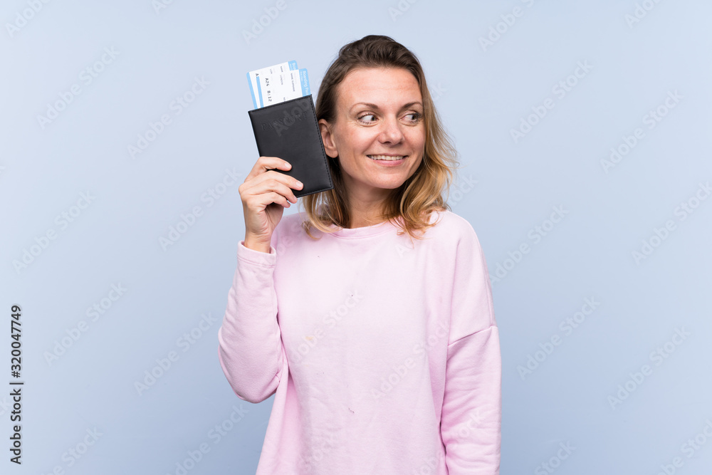Blonde woman over isolated background happy in vacation with passport and plane tickets Blonde woman over isolated background happy in vacation with passport and plane tickets