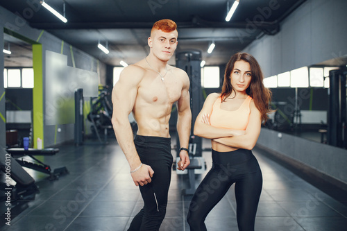 Guy and girl in the gym. A boy and girl perform exercises. Sports people in the gym
