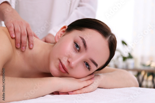 Portrait young beautiful woman lying on the massage table in spa wellness salon. Beauty and health procedures for women concept. Close up  copy space  background.