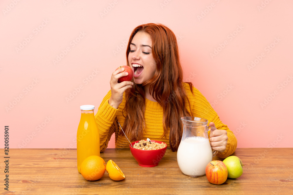 Teenager redhead girl having breakfast in a table Teenager redhead girl having breakfast in a table