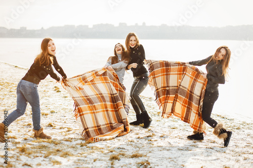 young and stylish four girls have fun in a winter park