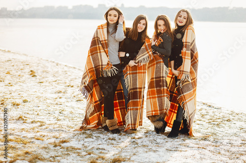 young and stylish four girls have fun in a winter park