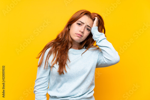 Teenager redhead girl over isolated yellow background with an expression of frustration and not understanding
