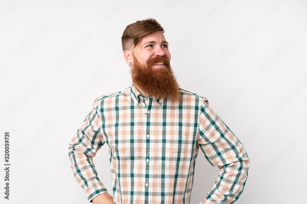 Redhead man with long beard over isolated white background posing with arms at hip and smiling Redhead man with long beard over isolated white background posing with arms at hip and smiling