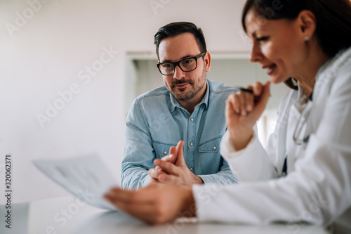 Close-up image of smiling man listening to a female healthcare worker, portrait. photo