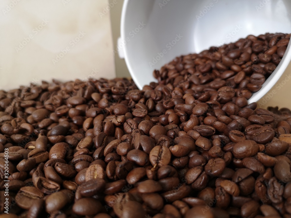 Fototapeta premium coffee beans coming out of the cup