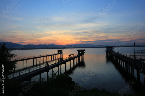 Sunset or sunrise over reservoil and pump station for water consmer supply