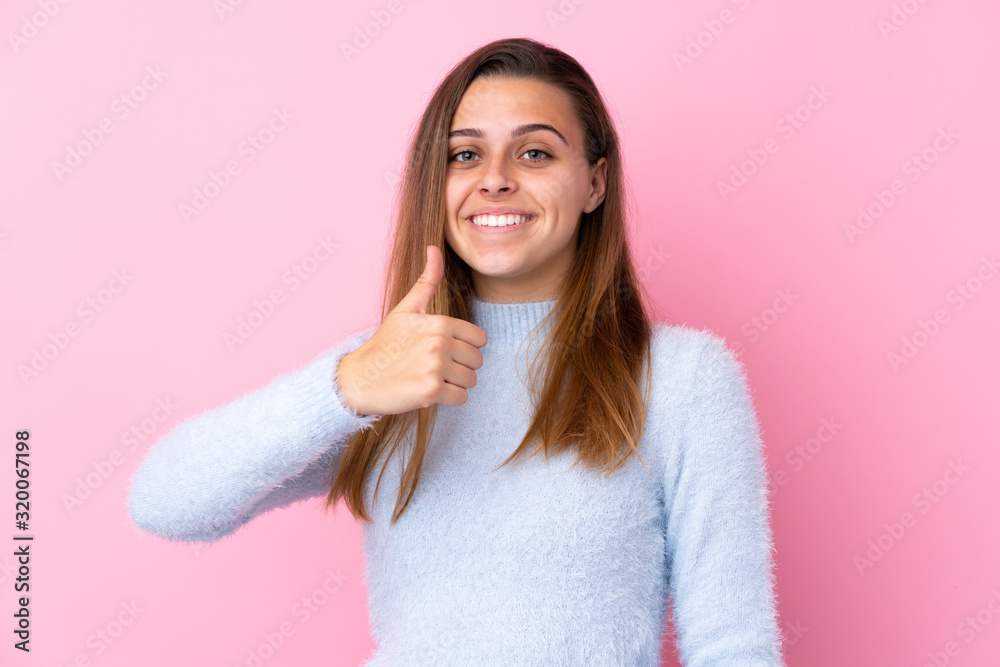 Teenager girl with blue sweater over isolated pink background giving a thumbs up gesture Teenager girl with blue sweater over isolated pink background giving a thumbs up gesture
