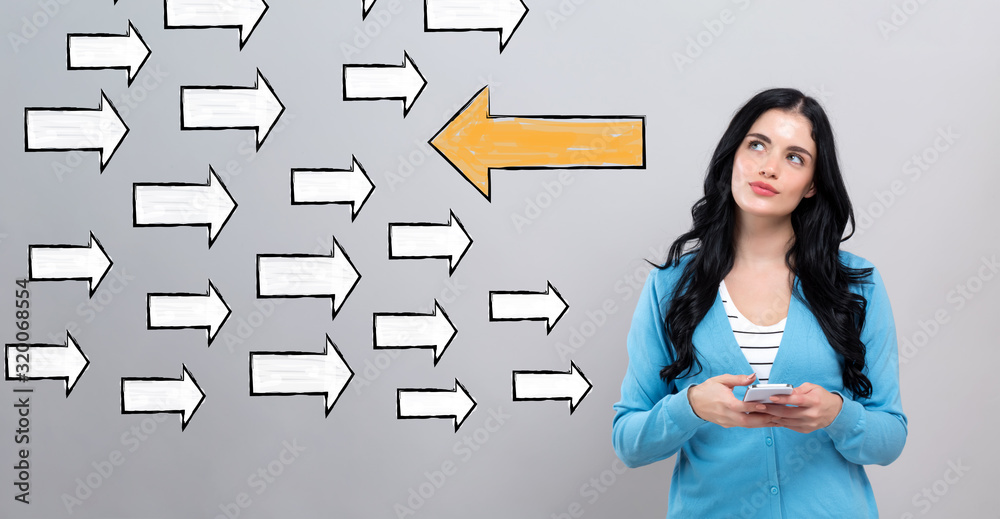 Arrow going in the opposite direction with thoughtful young woman holding a smartphone Arrow going in the opposite direction with thoughtful young woman holding a smartphone