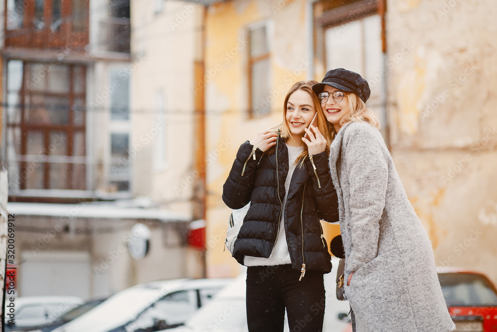 Fototapeta premium Fashion girl in a winter city. Girl in a glasses. Lady use the phone
