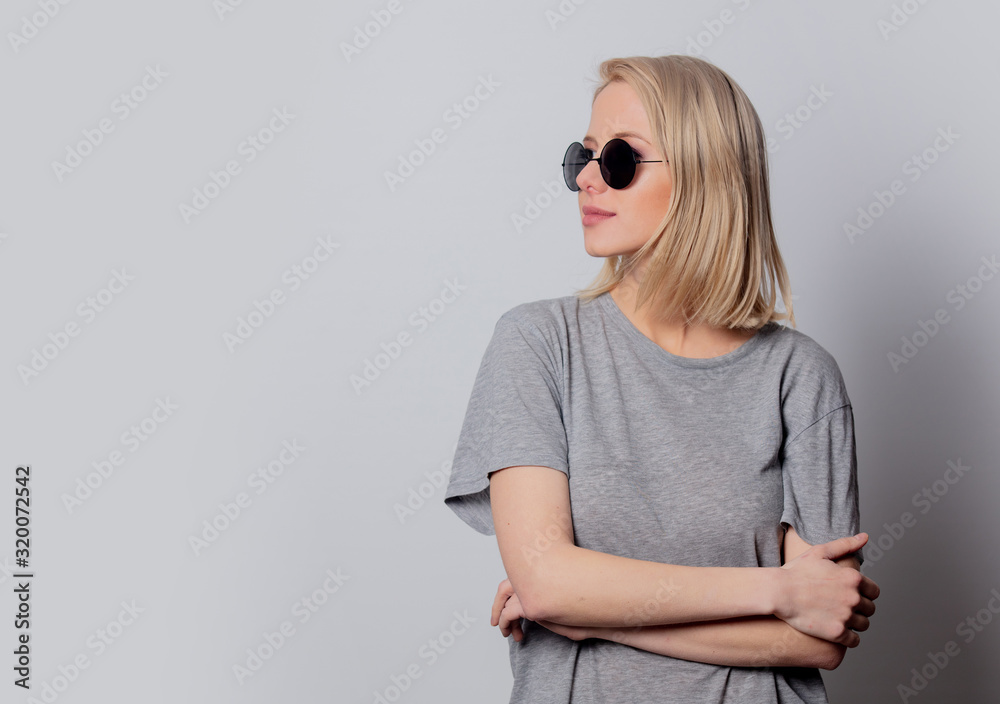 Fototapeta premium serious blonde woman in sunglasses on white background