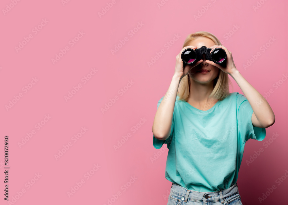 Beautiful smiling woman with binoculars on pink background Beautiful smiling woman with binoculars on pink background