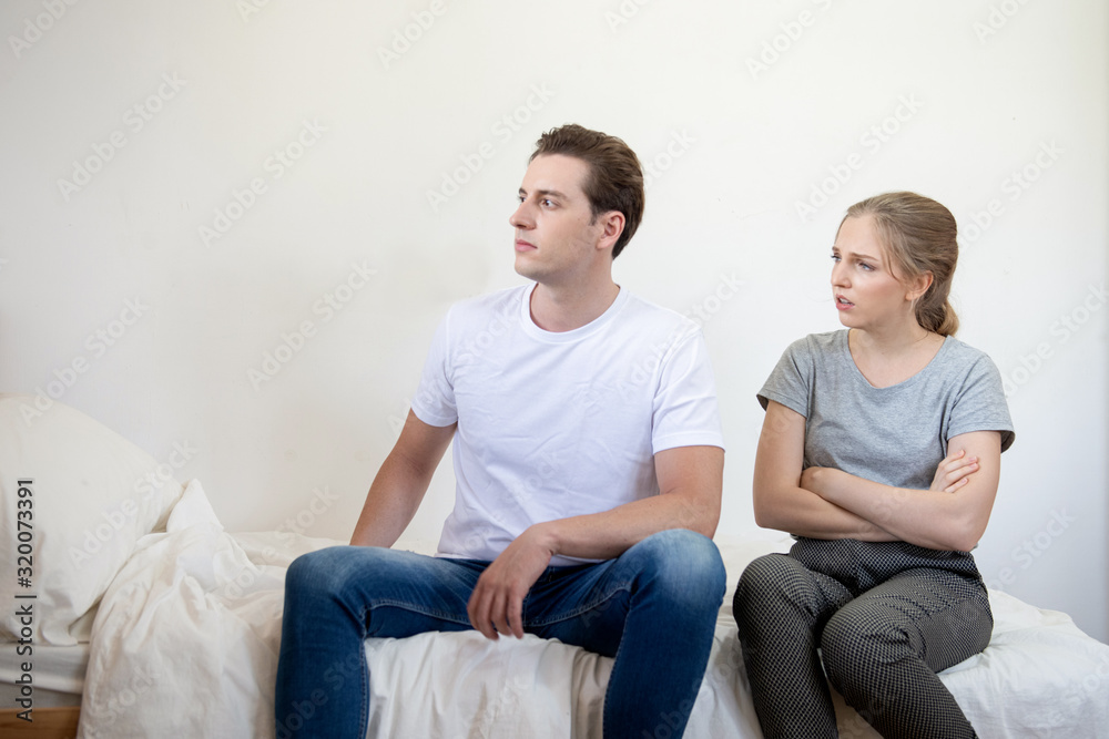 Unhappy caucasian couple having an argument in living room at home,not talking after dispute, teenagers quarrel, family crisis and relationships problems.