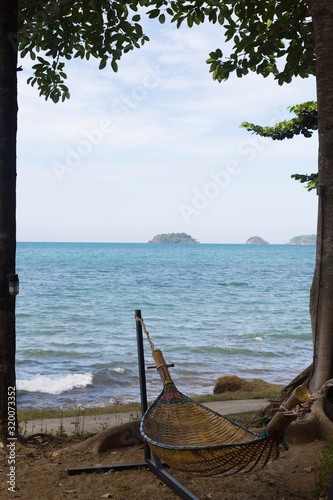 Wicker hammock on a tropical beach sea background.