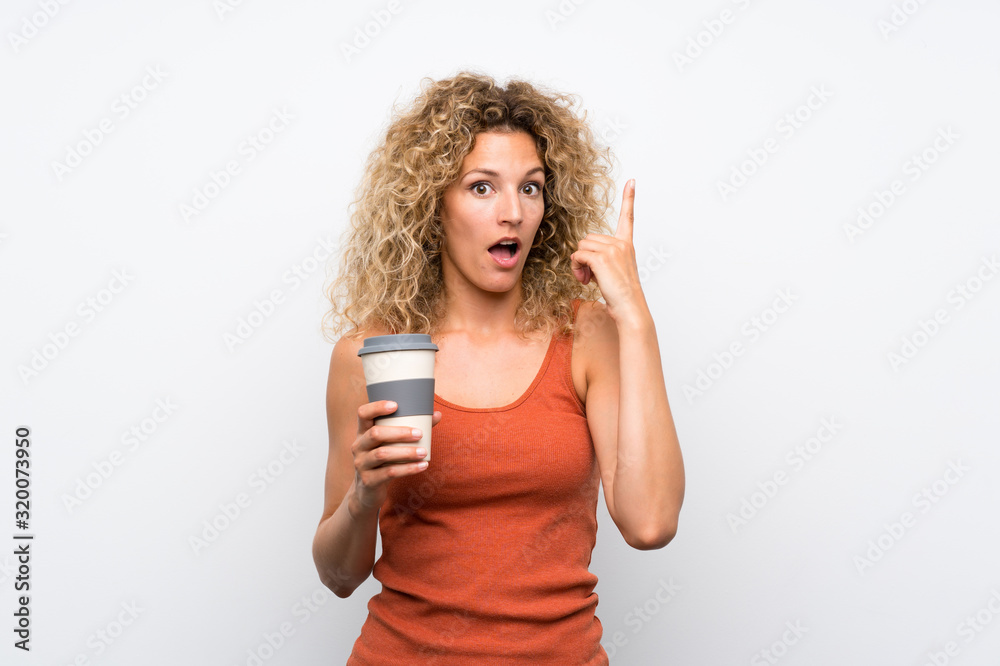 Young blonde woman with curly hair holding a take away coffee pointing up a great idea Young blonde woman with curly hair holding a take away coffee pointing up a great idea