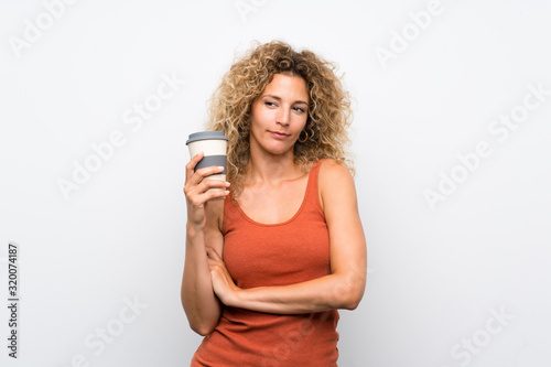 Young blonde woman with curly hair holding a take away coffee