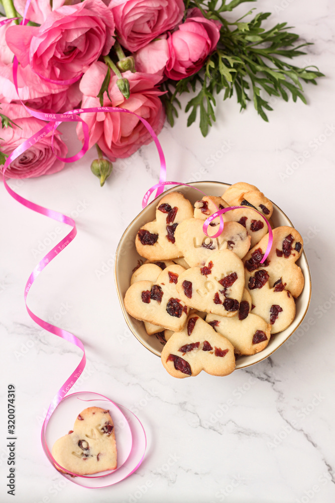 Valentine's day cookies on the table with a bouquet of flowers