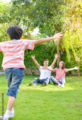 A happy young family spends time playing together in the garden at the front of house the vacation.