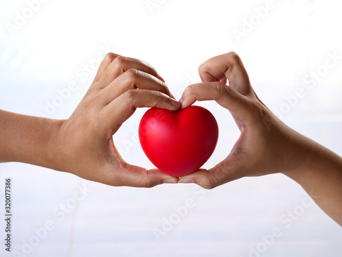 Hands holding a red heart to give with love on  Valentine s day concept  isolated on white background.