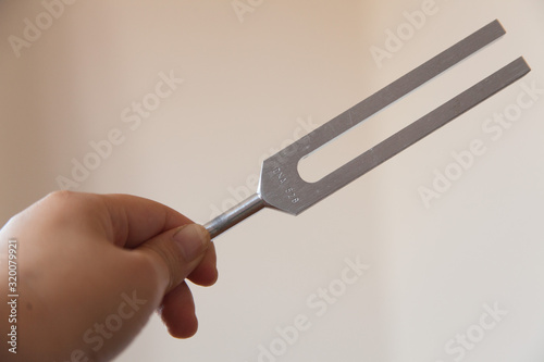 Fotografija Hand holding a tuning fork and crystal stone  .