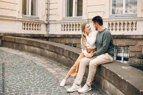 Cute couple in a city. Lady in a white blouse. Guy in a green sweater