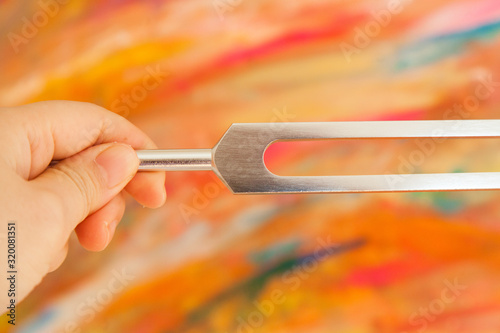 Hand holding a tuning fork .