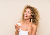 Young blonde woman with curly hair with moisturizer