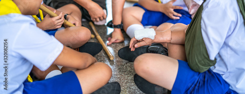 Boy scouts using hand open wound rubber casualty simulation kit to learn how to first aid treatment in camp.