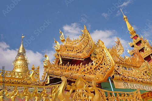View of the golden roof of a Burmese Pagoda in Mingun  Mandalay  against a blue sky.