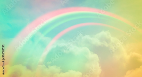 There are clouds and sky with rainbow as pastel background.