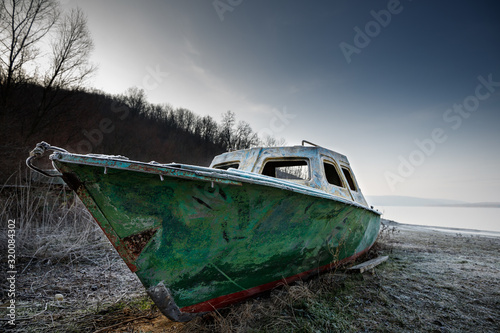 Φωτογραφία old fishing boat on the beach of the river