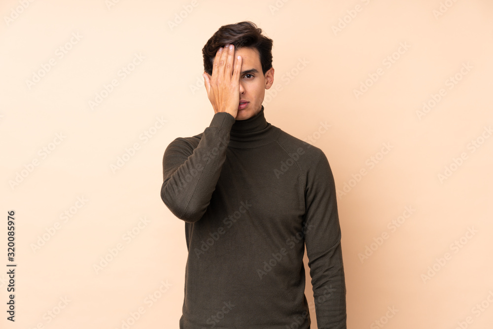 Man over isolated background covering a eye by hand