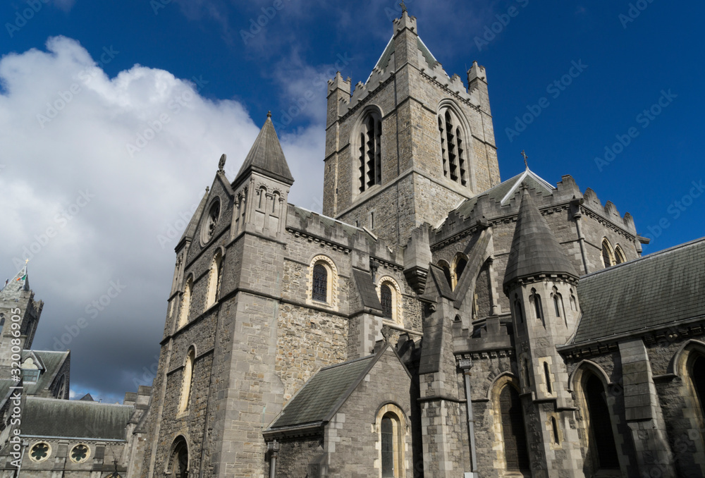 Gothic cathedral of the Holy Trinity with white clouds over blue sky in Dublin, Ireland.