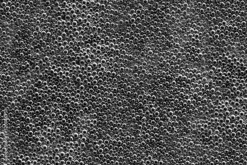 Seamless texture of water bubbles on a black background. Soft focus.