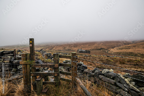 Misty and foggy day on the moors showing a stile and a derelict house- Hoof stones height