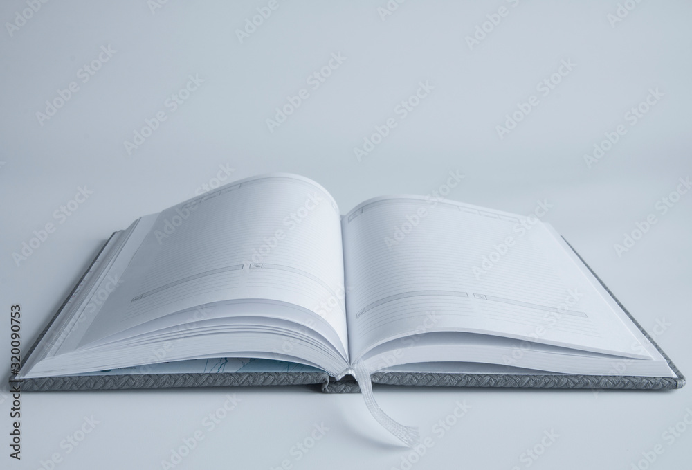 An open book or notebook with blank pages. On a white or gray background