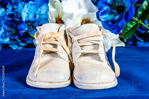 vintage white baby shoes on blue with blue and white flowers