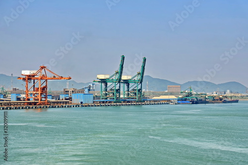 Type of cargo terminal and cranes, berths for transshipment of bulk cargo, iron ore and coal. Port Zhuhai, China.