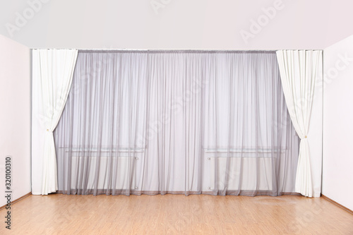 Windows with elegant curtains and blinds in empty room