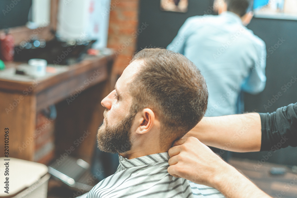 Haircut at the hairdresser. Barber cuts the hair on the client's head. The process of creating hairstyles for men. A man in a barbershop. The near plan. Equipment stylist. Selective focus Haircut at the hairdresser. Barber cuts the hair on the client's head. The process of creating hairstyles for men. A man in a barbershop. The near plan. Equipment stylist. Selective focus